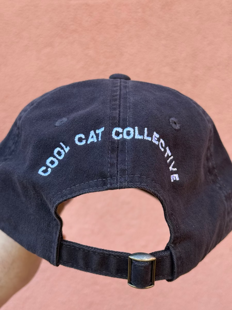 Black cap with 'Cool Cat Collective' text on a pink background