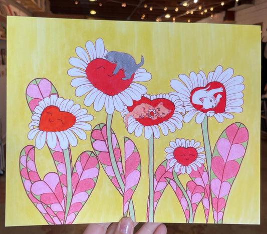 Hand holding a colorful card with floral designs on a yellow background.